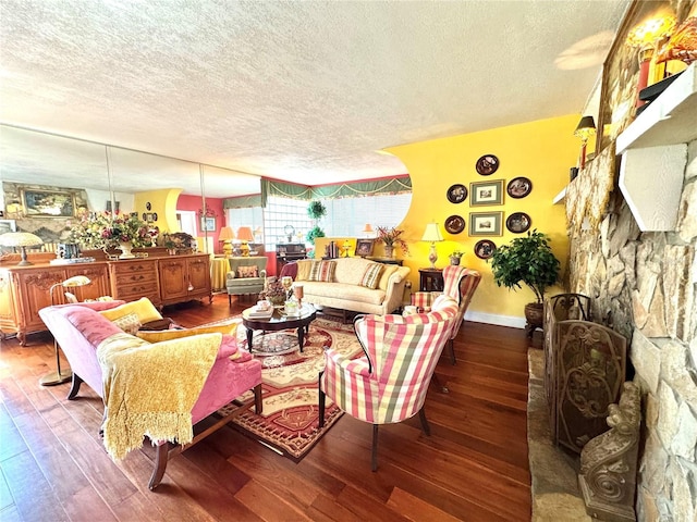 living area featuring a textured ceiling, dark wood-type flooring, and baseboards