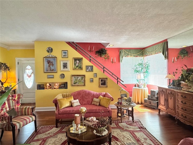 living room featuring a textured ceiling, baseboards, and wood finished floors