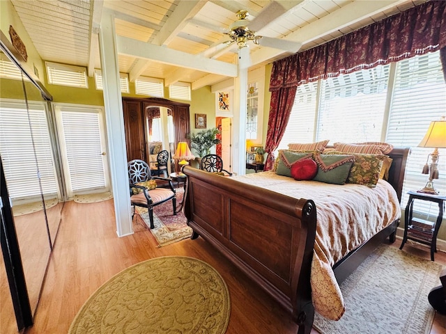 bedroom featuring ceiling fan, wooden ceiling, wood finished floors, and beam ceiling