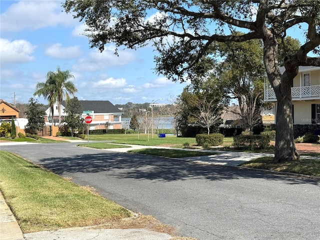 view of street featuring traffic signs, a residential view, and sidewalks