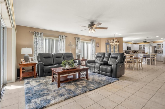 tiled living room featuring ceiling fan with notable chandelier