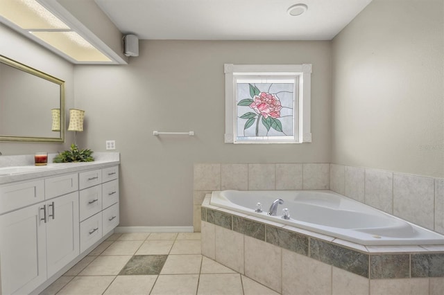 bathroom with tile patterned flooring, vanity, and a relaxing tiled tub