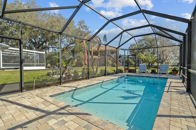 view of pool with glass enclosure and a patio area