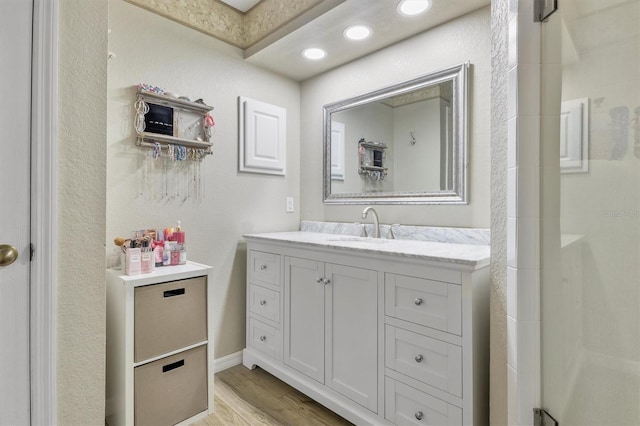 full bath featuring recessed lighting, vanity, a shower, and wood finished floors