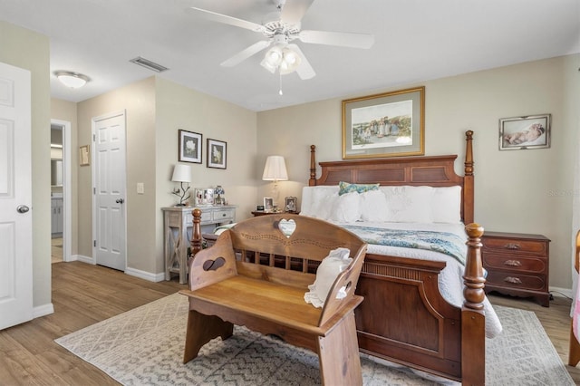bedroom featuring ceiling fan, visible vents, baseboards, and light wood-style flooring