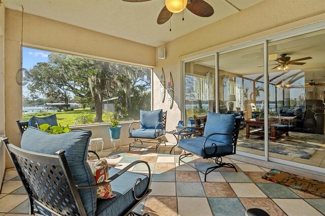 sunroom / solarium featuring a healthy amount of sunlight and a ceiling fan