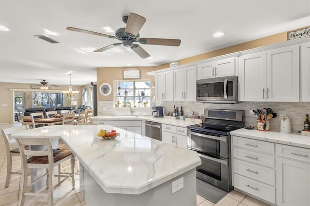 kitchen featuring visible vents, a sink, white cabinets, appliances with stainless steel finishes, and backsplash