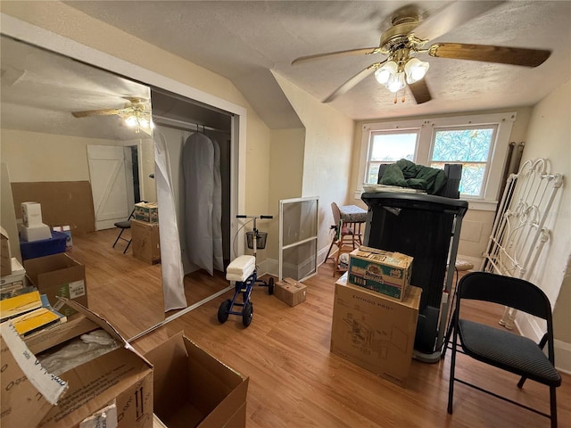 interior space with ceiling fan, a textured ceiling, and light wood-type flooring