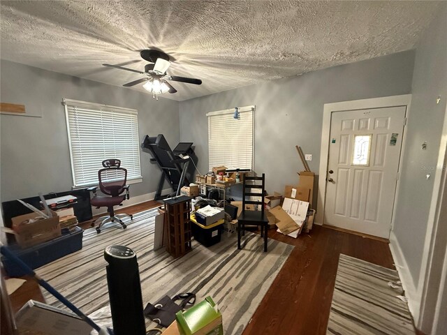 workout area featuring hardwood / wood-style flooring, ceiling fan, and a textured ceiling