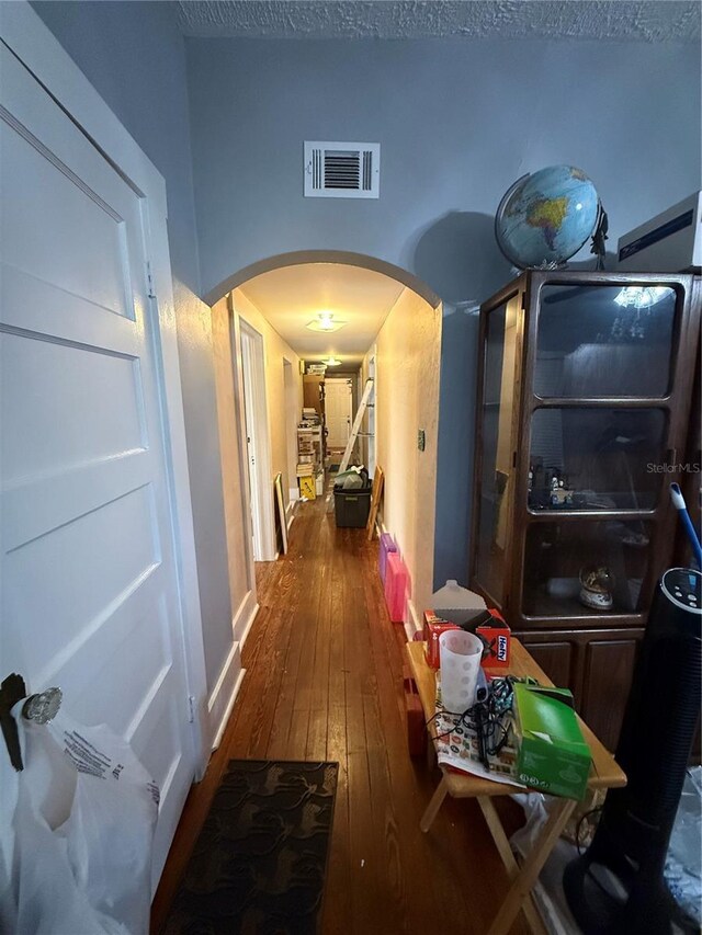 hallway with dark hardwood / wood-style flooring and a textured ceiling