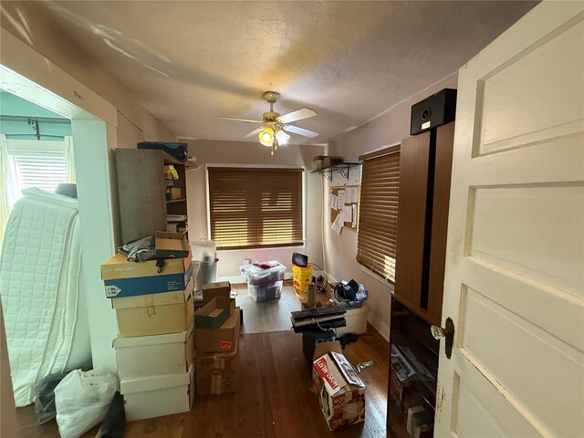 interior space featuring a textured ceiling, dark wood-type flooring, and ceiling fan