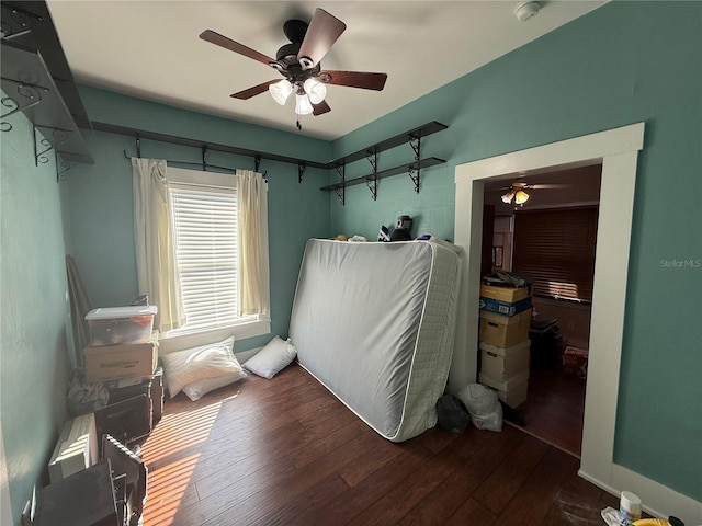 bedroom with dark hardwood / wood-style flooring and ceiling fan