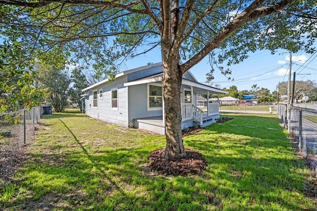 view of property exterior with covered porch and a lawn