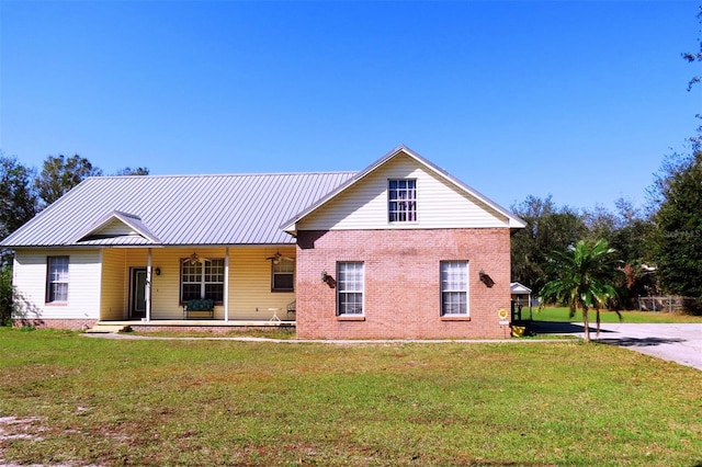 back of house featuring covered porch and a lawn