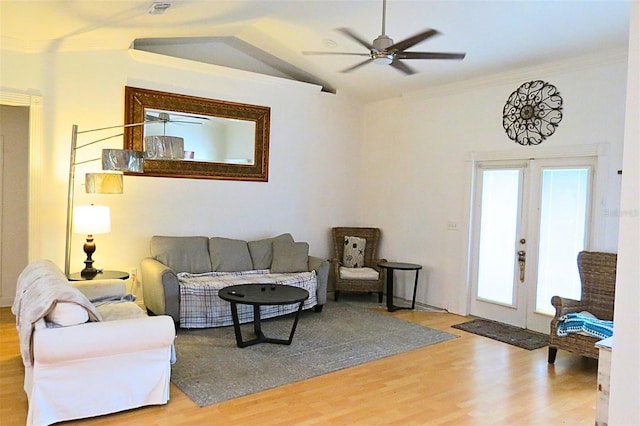 living room featuring wood-type flooring, lofted ceiling, ornamental molding, ceiling fan, and french doors