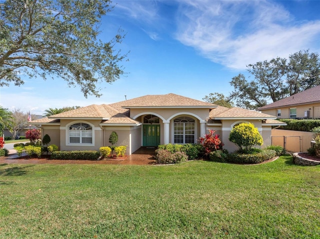 mediterranean / spanish home featuring a front lawn