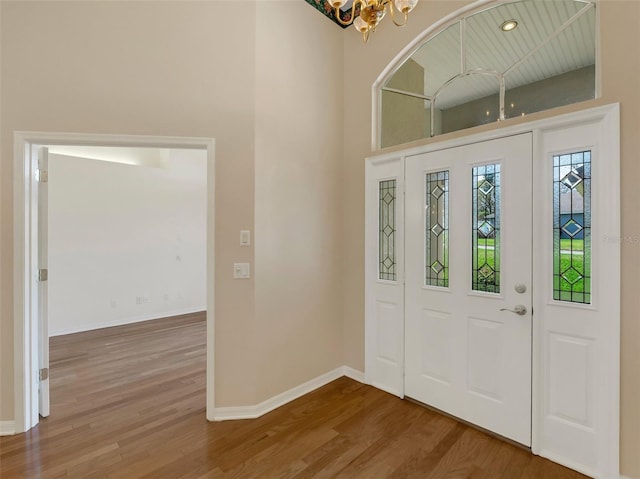 entrance foyer with an inviting chandelier and hardwood / wood-style flooring