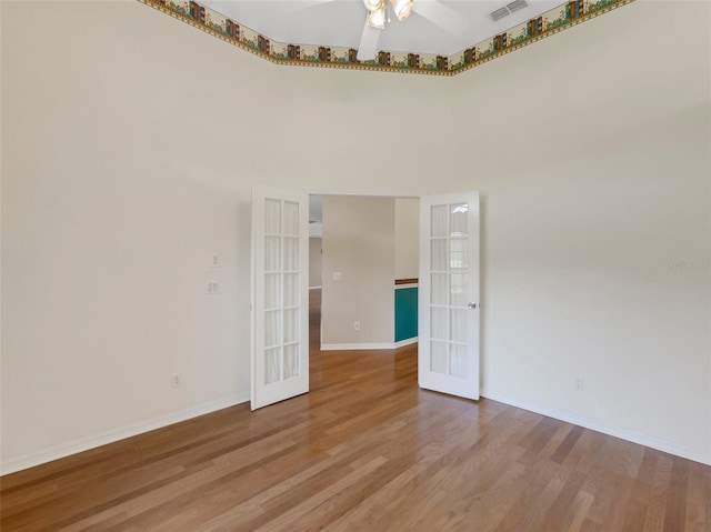 unfurnished room with wood-type flooring, ceiling fan, and french doors