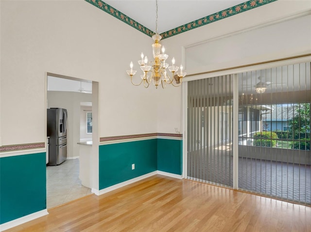 unfurnished dining area featuring wood-type flooring and a chandelier