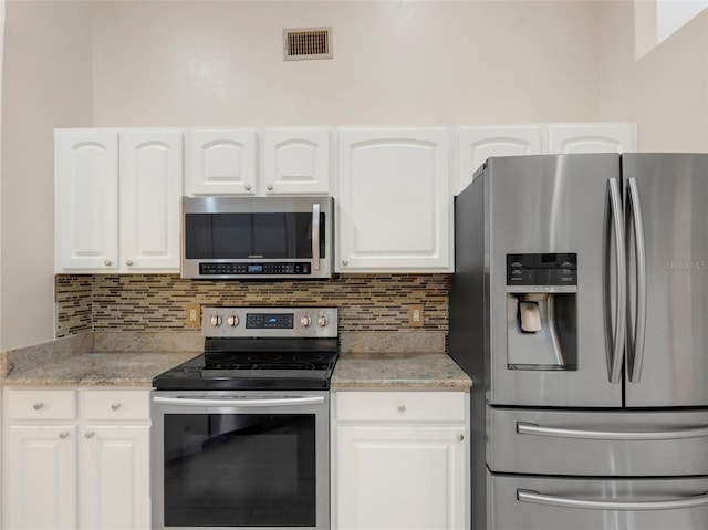 kitchen featuring backsplash, stainless steel appliances, and white cabinets