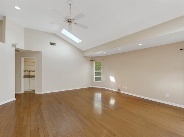 unfurnished living room with ceiling fan, high vaulted ceiling, a skylight, and hardwood / wood-style floors