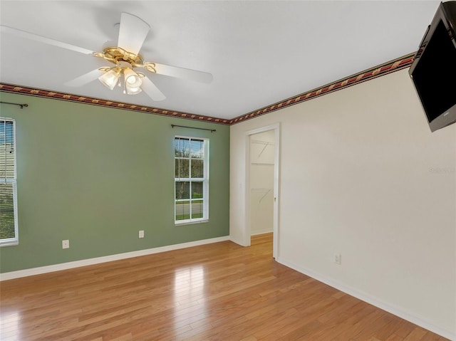 empty room with light hardwood / wood-style flooring and ceiling fan