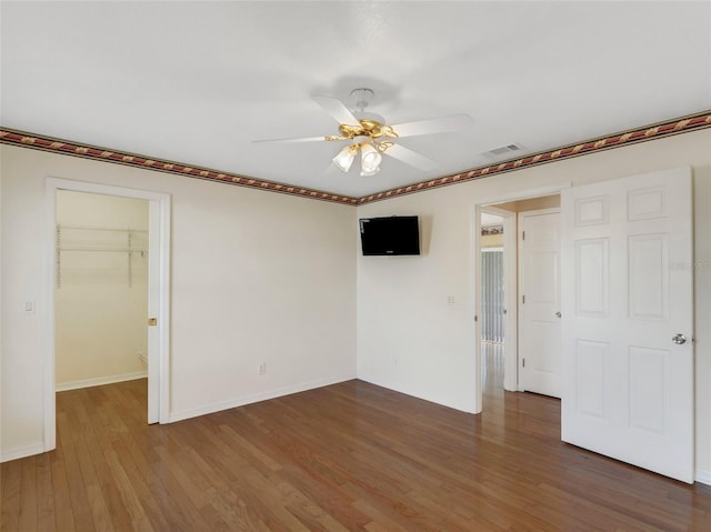 unfurnished room featuring dark wood-type flooring and ceiling fan