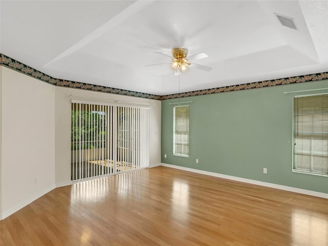 empty room with plenty of natural light, ceiling fan, and light hardwood / wood-style flooring