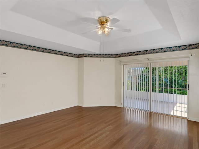 unfurnished room featuring hardwood / wood-style flooring, ceiling fan, and a tray ceiling