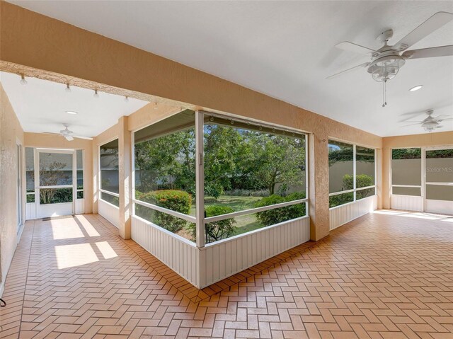 unfurnished sunroom featuring ceiling fan