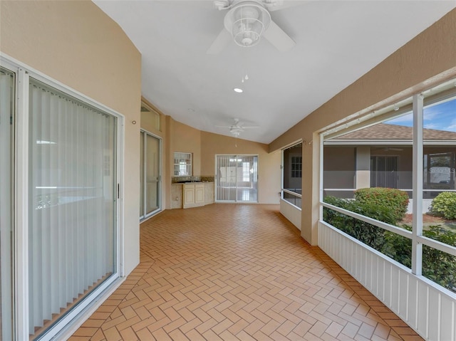 unfurnished sunroom with lofted ceiling and ceiling fan