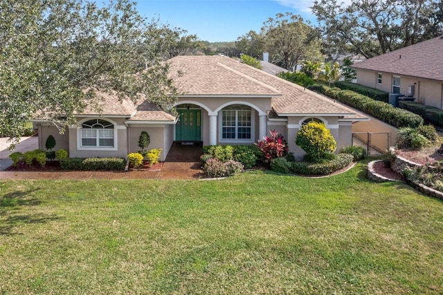 mediterranean / spanish home with a front yard, french doors, and central air condition unit