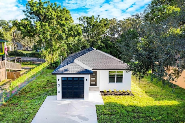 view of front facade featuring a front lawn, fence, stucco siding, driveway, and an attached garage