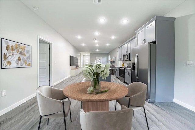 dining area with recessed lighting, light wood-type flooring, and baseboards