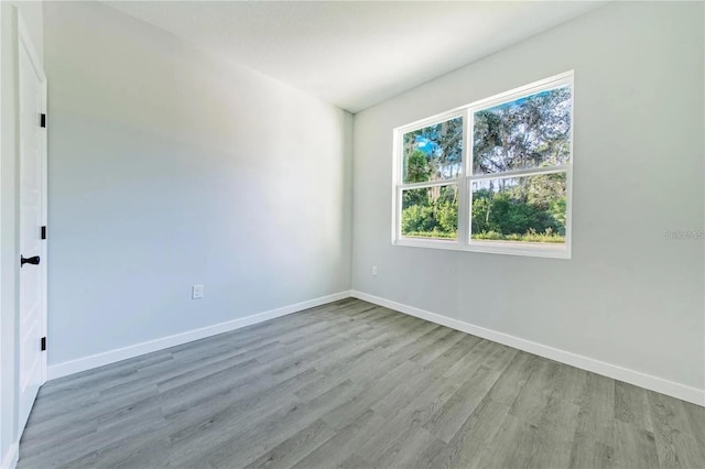 empty room with baseboards and wood finished floors