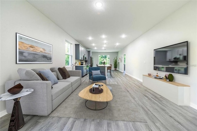 living area with recessed lighting, baseboards, and light wood-style floors