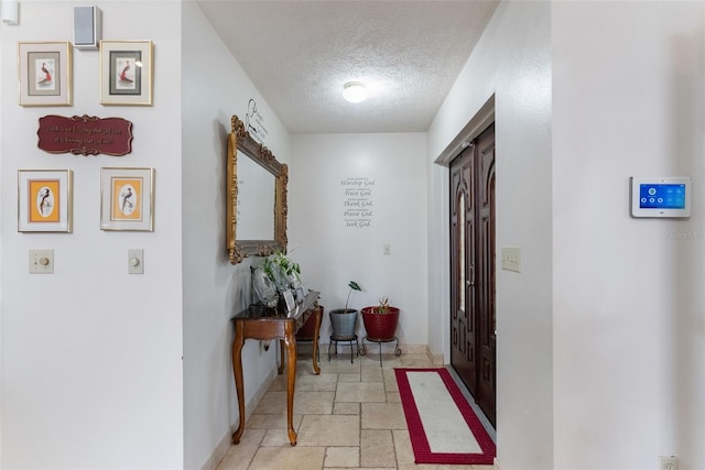 hall with a textured ceiling