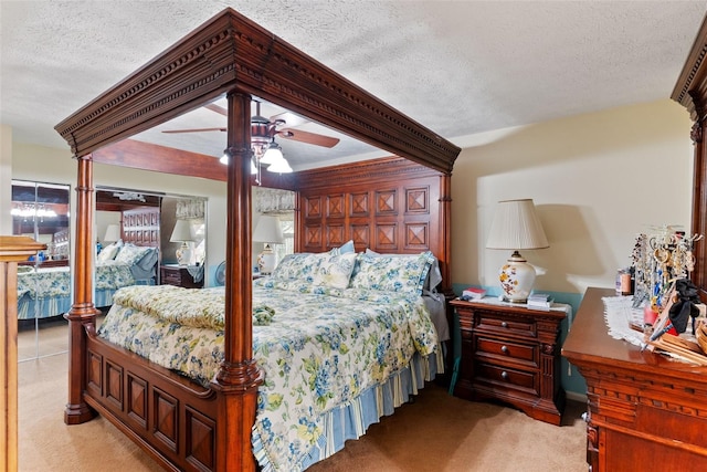 bedroom with ceiling fan, light colored carpet, and a textured ceiling