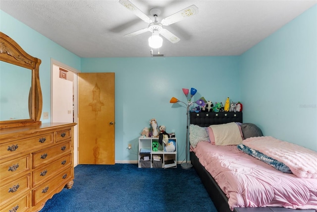 carpeted bedroom featuring ceiling fan and a textured ceiling