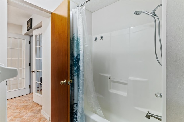 bathroom featuring french doors, tile patterned floors, and shower / tub combo