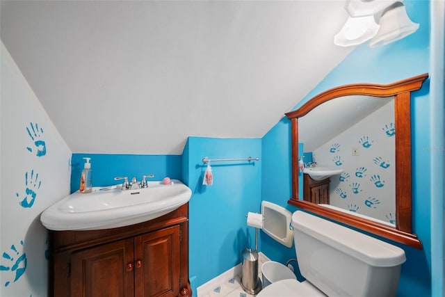 bathroom with vanity, lofted ceiling, and toilet