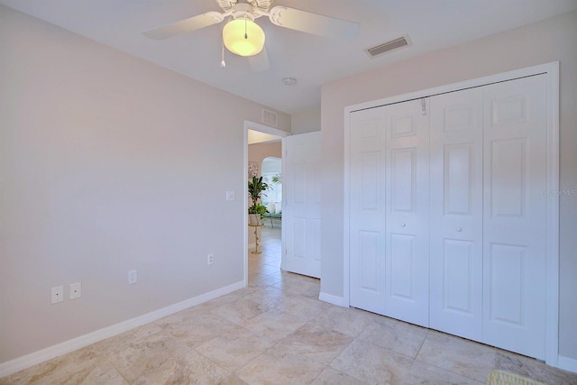 unfurnished bedroom with ceiling fan and a closet