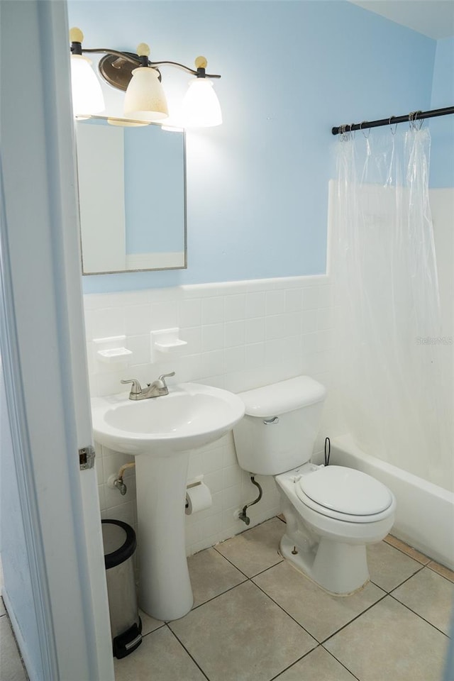 bathroom featuring shower / bath combo, tile walls, tile patterned floors, and toilet