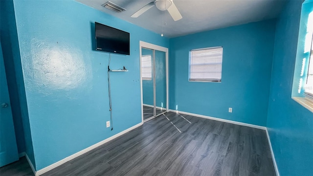 unfurnished bedroom with ceiling fan, dark hardwood / wood-style flooring, and a closet