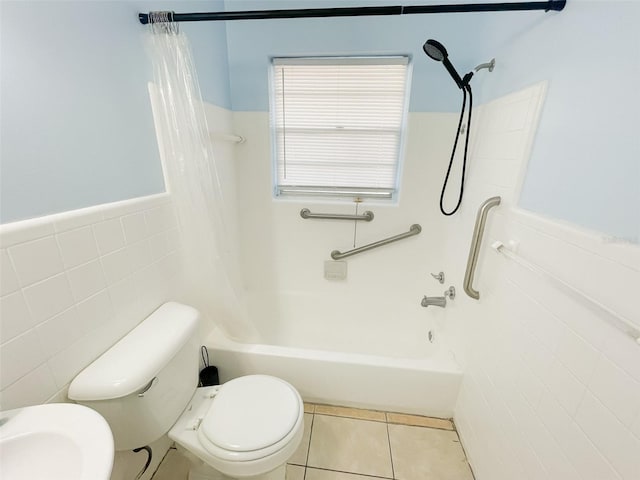 bathroom featuring shower / bath combo with shower curtain, tile patterned floors, toilet, and tile walls