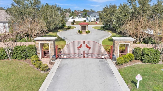 view of gate with a yard