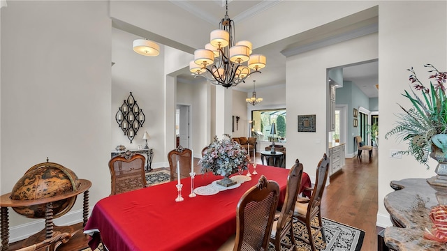 dining room with a notable chandelier, crown molding, and dark hardwood / wood-style floors