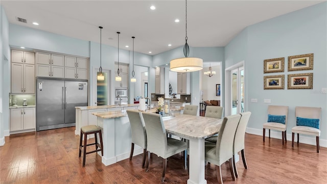 dining space featuring hardwood / wood-style flooring and ornate columns