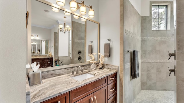 bathroom with crown molding, vanity, and a tile shower