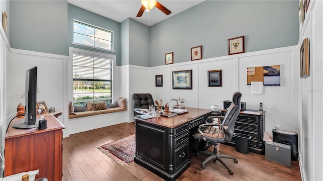 office space with dark hardwood / wood-style flooring, ceiling fan, and a high ceiling